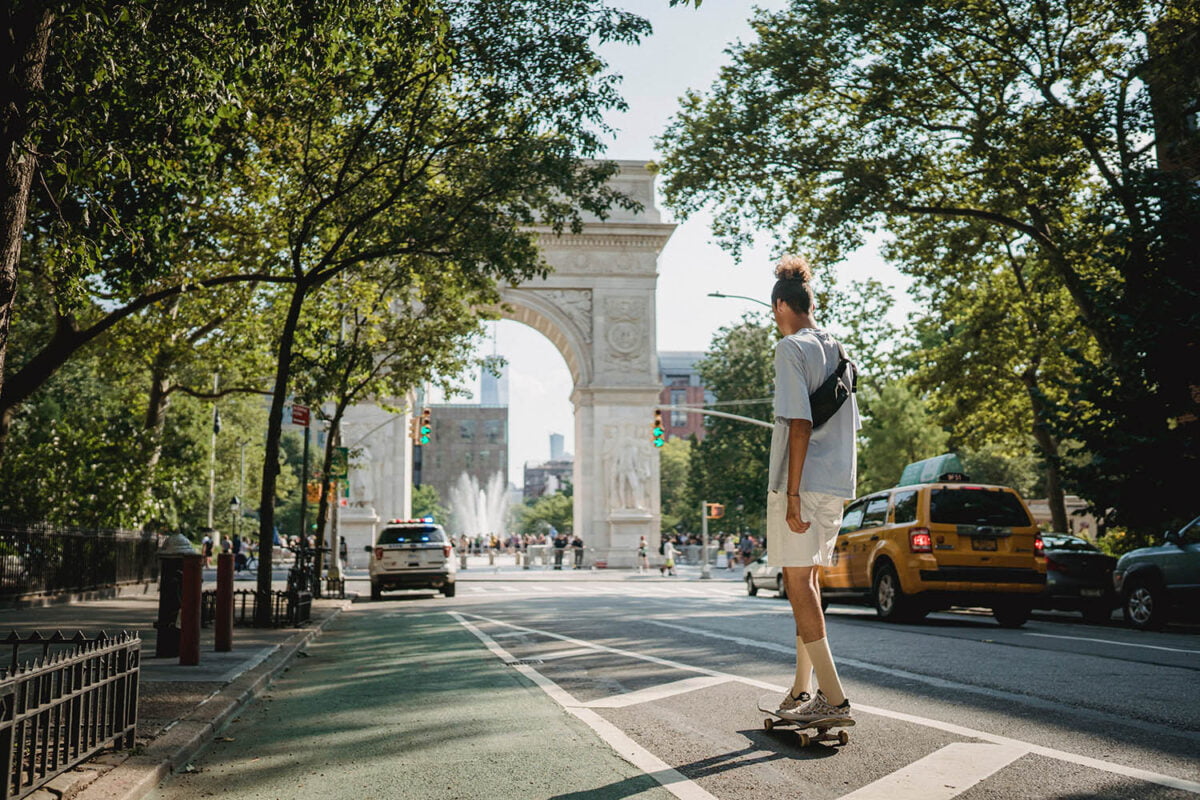Man om a skateboard heading towards Washington Square Park - Behind the Scenes NYC